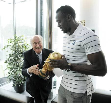 Fussball International FIFA 28.08.2013 Der sechsmaliger Olympiasieger und achtmaliger Weltmeister Usain Bolt (re, Jamaika) mit WM Pokal und FIFA Präsident Joseph S. Blatter (li, Schweiz) 