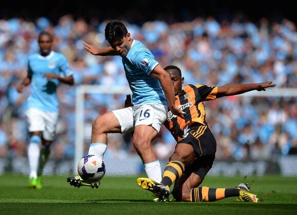 Sergio Kun Agüero of Manchester City is knocked off the ball by Maynor Figueroa of Hull City - Barclays Premier League - Manchester City vs Hull City - Etihad Stadium - Manchester - England - 31 08 13 - EDITORIAL USE ONLY. No use with unauthorised audio, video, data, fixture lists, club league logos or live services. Online in-match use limited to 120 images, no video emulation. No use in betting, games or single club league player publications.