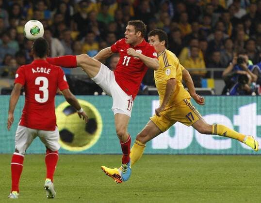 KIEV, UKRAINE. SEPTEMBER 10, 2013. England s Ashley Cole, James Milner and Ukraine s Artem Fedetskiy (L-R) fight for the ball in their 2014 FIFA World Cup Group H Round 10 qualifying match at the Olimpiysky National Sports Complex. The game ended in a 0:0 draw.  RE128ADD