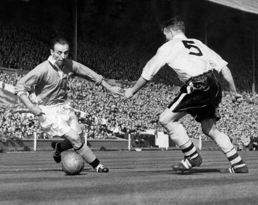 Stanley Matthews, the outside right for Blackpool coolly steers the ball past Bolton s centre half, Barrass in the thrilling FA Cup Final match at Empire Stadium, Wembley. 2nd May 1953  UnitedArchives00934576