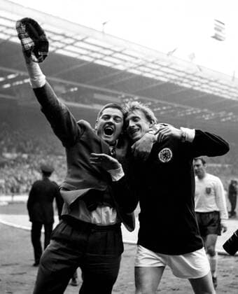 15th April 1967: A jubilant Scottish football fan embraces Scotland forward, Denis Law at the end of the match. Scotland won 3-2 against England.  UnitedArchives01009699