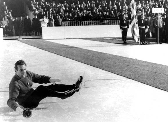 1956 Winter Olympic Games - Cortina dâÄ™Ampezzo, Italy 13,000 and 1,200 competitors gasped with surprise at the bearer of the Olympic torch fell over while skating into the stand during the opening ceremony of the Winter Olympic Games. The torch, a symbol of the highest amateur tradition was being carried in by Guido Catolli, as he skated round the rink on the last lap, he failed to notice a microphone wire laying on the ice and toppled over it. He kept a tight hold on the torch and finished the lap of honour before an ultra-silent audience. - Photo shows the Italian skater Guido Catolli ( Guido Caroli ) sitting on the ice after he had fallen over a wire laid on the skaters path. - 26 January 1956 - Â  UnitedArchives01026125