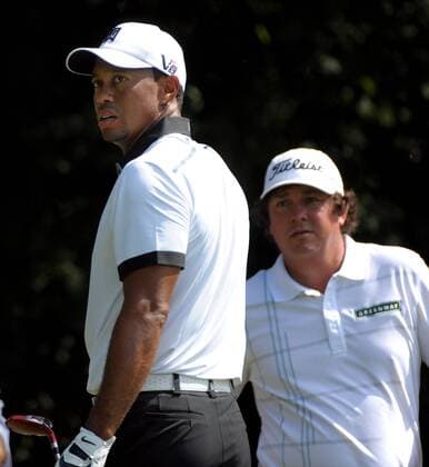 Tiger Woods (L) eyes his drive on hole two while playing partner Jason Dufner waits to hit during the second round of the PGA Golf Herren Tour Championship on September 20, 2013 at East Lake Golf Club in Atlanta. Woods began the round at 4 over par, nine strokes away from leader Henrik Stenson.  AJP2013092006