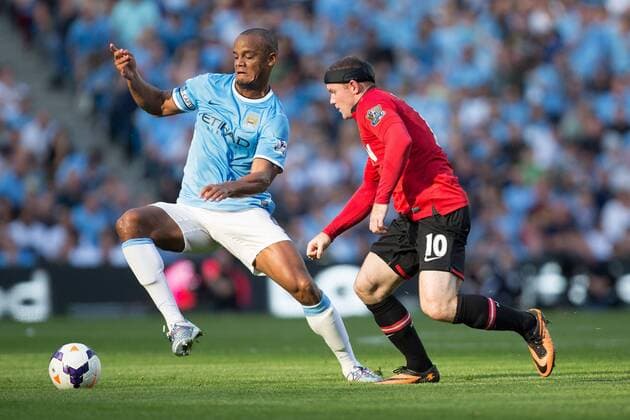 Vincent Kompany of Manchester City and Wayne Rooney of Manchester United in action - Manchester City vs Manchester United - Barclay s Premier League - Etihad Stadium - Manchester - 22 09 2013 EDITORIAL USE ONLY. No use with unauthorised audio, video, data, fixture lists, club league logos or live services. Online in-match use limited to 120 images, no video emulation. No use in betting, games or single club league player publications.