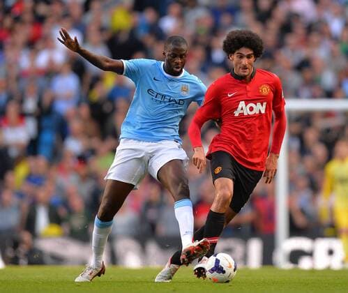 Yaya Toure of Manchester City challenges Mauroane Fellaini of Manchester United - Barclays Premier League - Manchester City vs Manchester Utd - Etihad Stadium - Manchester - 22 09 13 - EDITORIAL USE ONLY. No use with unauthorised audio, video, data, fixture lists, club league logos or live services. Online in-match use limited to 120 images, no video emulation. No use in betting, games or single club league player publications.