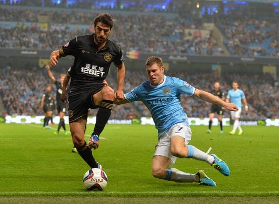 Jordi Gomez of Wigan Athletic tackled by James Milner of Manchester City - Capital One Cup - Third Round - Manchester City vs Wigan Athletic - Etihad Stadium - Manchester - 24 09 13 - Picture Simon Bellis Sportimage EDITORIAL USE ONLY. No use with unauthorised audio, video, data, fixture lists, club league logos or live services. Online in-match use limited to 120 images, no video emulation. No use in betting, games or single club league player publications.