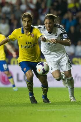 Football - 2013 2014 Premier League - Swansea City vs. Arsenal michu & mathieu flamini contest the ball at the Liberty Stadium. COLORSPORT WINSTON BYNORTH