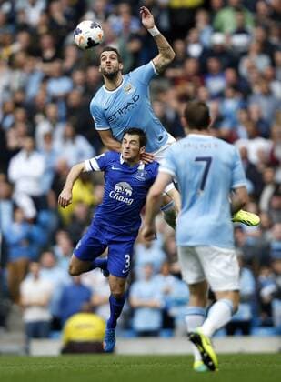 MANCHESTER, Alvaro Negredo (Top) of Manchester City vies with Leighton Baines of Everton during the Barclays Premier League match between Manchester City and Everton at Etihad Stadium in Manchester, Britain on Oct. 5, 2013. (Xinhua Wang Lili) FOR EDITORIAL USE ONLY. NOT FOR SALE FOR MARKETING OR ADVERTISING CAMPAIGNS. NO USE WITH UNAUTHORIZED AUDIO, VIDEO, DATA, FIXTURE LISTS, CLUB LEAGUE LOGOS OR LIVE SERVICES. ONLINE IN-MATCH USE LIMITED TO 45 IMAGES, NO VIDEO EMULATION. NO USE IN BETTING, GAMES OR SINGLE CLUB LEAGUE PLAYER PUBLICATIONS. (SP)BRITAIN-MANCHESTER-SOCCER-PREMIER LEAGUE-MAN CITY VS EVERTON 