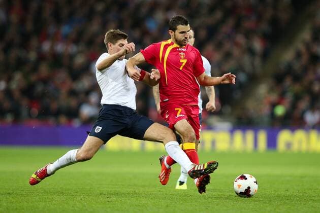 England v Montenegro - World Cup Qualifier - London - Wembley - England -11 10 2013 - England s Steven Gerrard challenges Montenegro s Simon Vukcevic Pic Charlie Forgham-Bailey Sportimage EDITORIAL USE ONLY. No use with unauthorised audio, video, data, fixture lists, club league logos or live services. Online in-match use limited to 120 images, no video emulation. No use in betting, games or single club league player publications.