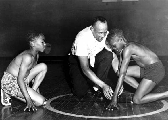 America s great Olympic track star Jesse Owens is showing two boys from the South Side Boys Club the starting position that brought him fame. Rajah Latimore (left) Sherman Davis 1st July 1954 kbdig 2000 quer coaching coloured guidance 