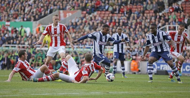 Stephane Sessegnon of West Bromwich Albion dribbles through the Stoke defence - Barclays Premier League Football - Stoke City vs West Bromwich Albion - Britannia Stadium Stoke - Season - 2013 14 19th October 2013 - Picture Malcolm Couzens Sportimage EDITORIAL USE ONLY. No use with unauthorised audio, video, data, fixture lists, club league logos or live services. Online in-match use limited to 120 images, no video emulation. No use in betting, games or single club league player publications.