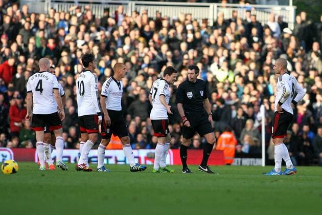 Football - 2013 2014 Premier League - Fulham vs. Manchester United The Fulham players surround Referee Mr Lee Probert after a free kick wasn t given before Manchester United scored there second goal at Craven Cottage Colorsport Shaun Boggust 