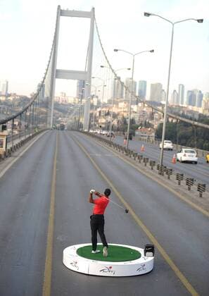 U.S. golfer Tiger Woods hits a ball as he poses during an event to promote the upcoming Turkish Airlines Open golf tournament, on the Bosphorus Bridge that links the city s European and Asian sides, in Istanbul, on November 5, 2013. Woods is in Turkey to attend the tournament, which will take place in Antalya, southern Turkey, between November 7 to 10, 2013. 