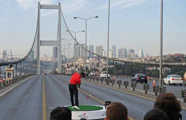 (131105) -- ISTANBUL, Nov. 5, 2013 (Xinhua) -- U.S. golfer Tiger Woods hits a ball as he poses during an event to promote the upcoming Turkish Airlines Open 2013 golf tournament, on the Bosphorus Bridge that links the city s European and Asian sides in Istanbul on Nov. 5, 2013. The game will start on Thursday at the Mediterranean city Antalya of Turkey. (Xinhua Lu Zhe) TURKEY-ISTANBUL-GOLF-TIGER WOODS 