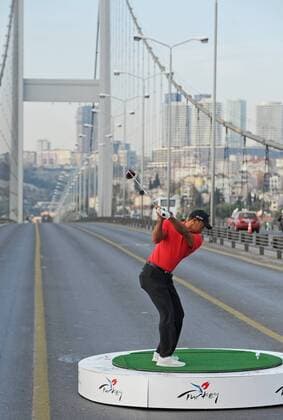 (131105) -- ISTANBUL, Nov. 5, 2013 (Xinhua) -- U.S. golfer Tiger Woods hits a ball as he poses during an event to promote the upcoming Turkish Airlines Open 2013 golf tournament, on the Bosphorus Bridge that links the city s European and Asian sides in Istanbul on Nov. 5, 2013. The game will start on Thursday at the Mediterranean city Antalya of Turkey. (Xinhua Lu Zhe) TURKEY-ISTANBUL-GOLF-TIGER WOODS 