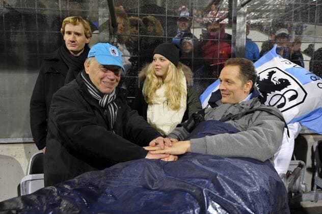 10.11.2013, Fussball TSV 1860 München, Benefizspiel ran Helden zu gunsten des chronisch kranken Ex-Löwen-Spielers OlafBodden, 1860 München All Stars - ran Bundesliga All Stars, im Grünwalderstadion München. Ex-Trainer Karsten Wettberg (li) begrüßt Olaf Bodden der im Krankenbett am Spielfeldrand liegt. Mitte Tochter Anisia Bodden.