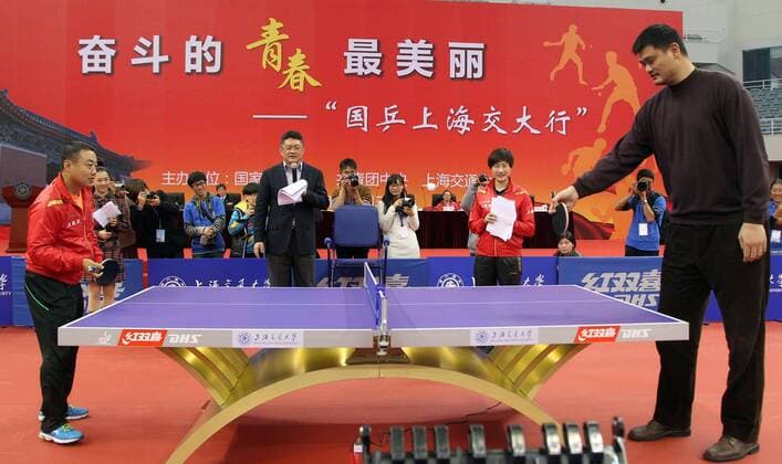 Former NBA Basketball Herren USA basketball player Yao Ming, right, plays table tennis with Liu Guoliang, left, head coach of the Chinas National Mens table tennis team and former Chinese table tennis player who won all titles at major world tournaments, during Chinas National table tennis teams visit to Shanghai Jiaotong University in Shanghai, China, 3 December 2013. Gegensätze Größenunterschied Yao Ming plays ping-pong with world champion in Shanghai Jiaotong University  pau920015_01