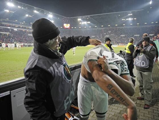 04.12.2013, Fussball DFB-Pokal 2013 2014, Achtelfinale, FC Augsburg - FC Bayern München, in der SGL-Arena Augsburg, Fotograf hilft Jerome Boateng (Bayern München) nach dem Spiel aus dem Trikot weil Boateng es einem Fan schenken will.