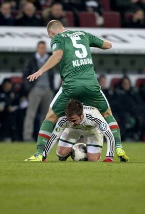 04.12.2013, Fussball DFB-Pokal 2013 2014, Achtelfinale, FC Augsburg - FC Bayern München, in der SGL-Arena Augsburg, Mario Götze (Bayern) krabbelt unter Ragnar Klavan (Augsburg) durch.