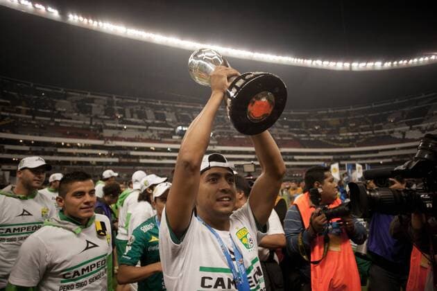 (131215) -- Mexico City, Dec 15, 2013 (Xinhua) -- Elias Hernandez of Leon holds up the thropy with team mates after their team won the Mexican league championship final soccer match against America at the Azteca stadium in Mexico City on Dec. 15, 2013. (Xinhua Pedro Mera) (SP)MEXICO-MEXICO CITY-SOCCER-AMERICA VS LEON 