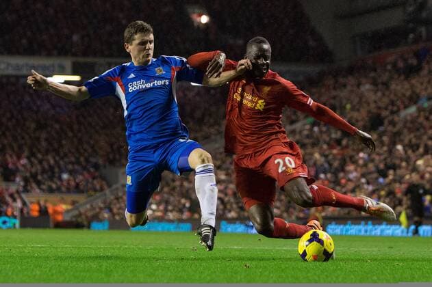 Aly Cissokho of Liverpool slides a cross past Hull s Alex Bruce - Liverpool vs. Hull City - Barclays Premier League - Anfield - Liverpool - 01 01 2014 Pic Philip Oldham Sportimage EDITORIAL USE ONLY. No use with unauthorised audio, video, data, fixture lists, club league logos or live services. Online in-match use limited to 120 images, no video emulation. No use in betting, games or single club league player publications.