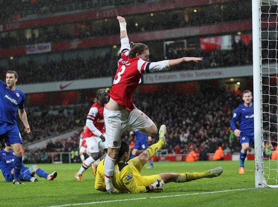 Arsenal s Nicklas Bendtner gets his ankle caught under the body of Cardiff s David Marshall as he scores - Arsenal FC London vs Cardiff City - Premier League - Emirates Stadium- London - England - 01 01 2014 - EDITORIAL USE ONLY. No use with unauthorised audio, video, data, fixture lists, club league logos or live services. Online in-match use limited to 120 images, no video emulation. No use in betting, games or single club league player publications.