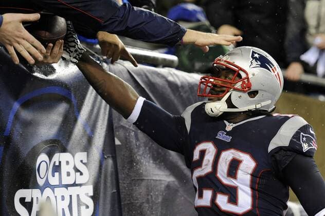 New England Patriots running back LeGarrette Blount (29) hands the football to a fan after he scored on a two-yard carry in the first quarter against the Indianapolis Colts in the AFC Divisional Playoff game at Gillette Stadium in Foxboro, Massachusetts on January 11, 2014. The Patriots defeated the Colts 43-22.  BOS2014011197