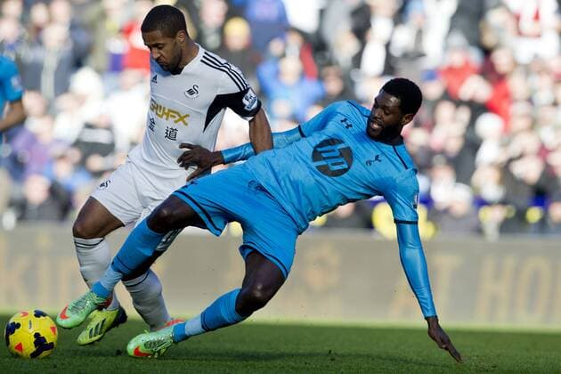 Football - 2013 2014 Premier League - Swansea City vs. Tottenham Hotspur Emmanuel Adebayor of Spurs tackled by Wayne Routledge of Swansea at the Liberty Stadium. 
