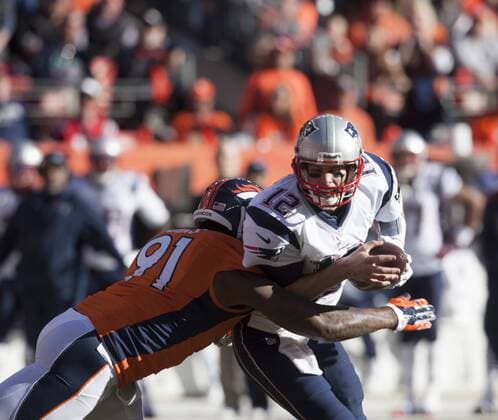 The New England Patriots Tom Brady Sacked by Robert Ayers in the second quarter in the AFC Championship game at Sports Authority Field at Mile High in Denver on January 19, 2014. The New England-Denver winner will play in Super Bowl XLVIII at MetLife Stadium in East Rutherford, New Jersey February 2nd.  DEN2014011913