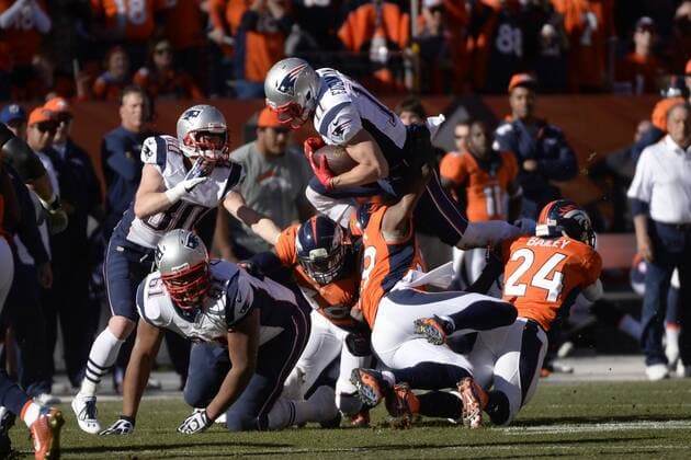 Jullian Edelman (11) of the New England Patriots dives over a pile of Denver Broncos during the AFC Championship game at Sports Authority Field at Mile High in Denver on January 19, 2014. The New England-Denver winner will play in Super Bowl XLVIII at MetLife Stadium  DEN20140119410