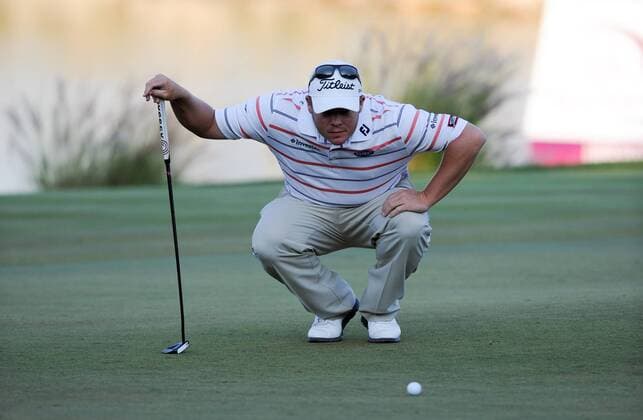 (140122) -- DOHA, Jan. 22, 2014 (Xinhua) -- George Coetzee of South Africa lines up his putt the ball during the first day match at Qatar Masters in Doha, Qatar, Jan. 22, 2014. (Xinhua Chen Shaojin) (SP)QATAR-DOHA-GOLF-QATAR MASTERS 