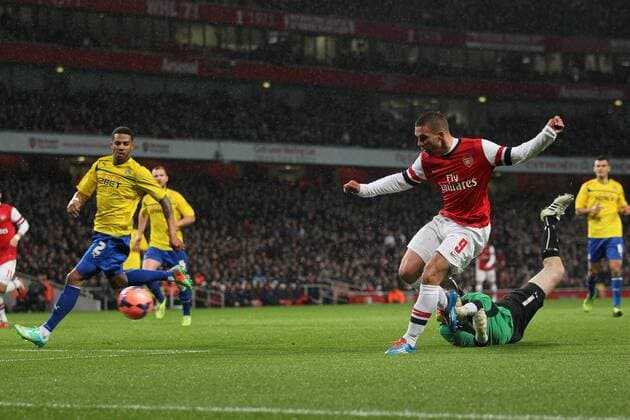 Arsenal s Lukas Podolski scoring his sides opening goal - Arsenal FC vs Coventry City - FA Cup Fourth Round - Emirates Stadium - London - England - 24 01 2014 - EDITORIAL USE ONLY. No use with unauthorised audio, video, data, fixture lists, club league logos or live services. Online in-match use limited to 120 images, no video emulation. No use in betting, games or single club league player publications.