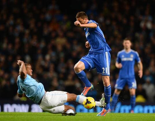 Vincent Kompany of Manchester City catches Nemanja Matic of Chelsea on the shin as he tackles him - Barclays Premier League - Manchester City vs Chelsea FC - Etihad Stadium - Manchester - England - 03rd February 2014 - EDITORIAL USE ONLY. No use with unauthorised audio, video, data, fixture lists, club league logos or live services. Online in-match use limited to 120 images, no video emulation. No use in betting, games or single club league player publications.