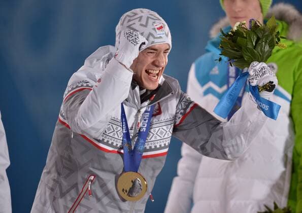Poland s Kamil Stoch celebrates after he was presented a gold medal during the victory ceremony for men s individual normal hill ski jumping at the Sochi 2014 Winter Olympics on February 10, 2014 in Sochi, Russia.  OLY20140210140