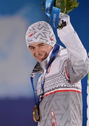 Poland s Kamil Stoch celebrates after he was presented a gold medal during the victory ceremony for men s individual normal hill ski jumping at the Sochi 2014 Winter Olympics on February 10, 2014 in Sochi, Russia.  OLY20140210141
