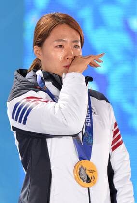 Gold medalist, South Korea s Sang Hwa Lee, wipes tears from her face as the South Korean national anthem is played during the victory ceremony for the ladies speed skating 500m at the Sochi 2014 Winter Olympics on February 12, 2014 in Sochi, Russia.  OLY20140212347