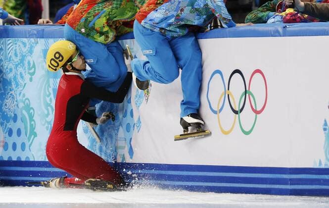(140213) -- SOCHI, Feb. 13, 2014 (Xinhua) -- Staff members jump to escape collision while China s Fan Kexin (L) falls during the ladies 500m semifinals of Short Track at the 2014 Sochi Winter Olympic Games in Sochi, Russia, Feb. 13, 2014. (Xinhua Wang Lili) (SP)OLY-RUSSIA-SOCHI-SHORT TRACK-LADIES 500M SEMIFINALS 