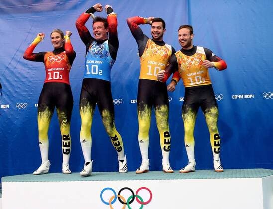 ITAR-TASS: SOCHI, RUSSIA. FEBRUARY 13, 2014. Gold medalists, Germany s Natalie Geisenberger, Felix Loch, Tobias Wendl and Tobias Arlt (L-R) celebrate victory at a flower ceremony following the Luge Team Relay competition at the 22nd Winter Olympic Games in Sochi, at the Sanki Sliding Center.  Highlight RE1392D4
