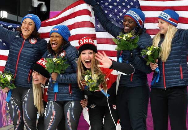 Canada s gold medalists, pilot Kaillie Humphries (2L) and brakewoman Heather Moyse (C) celebrate with U.S. silver medalists, pilot Elana Meyers (L) and brakewoman Lauryn Williams (3L) and compatriots bronze medalists, pilot Jamie Greubel (R) and brakewoman Aja Evans, during the flower ceremony of the women s bobsleigh during the Sochi Winter Olympics on February 19, 2014.  OLY20140219503