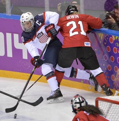 United States Meghan Duggan (L) makes a pass as Canada s Haley Irwin defends during the first period of the women s gold medal ice hockey game at the Sochi 2014 Winter Olympics on February 20, 2014 in Sochi, Russia.  OLY20140220124