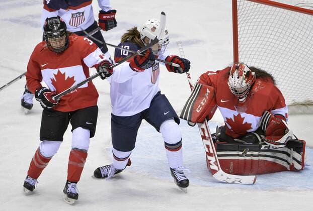 Canada s goalie Shannon Szabados (R) makes a save as United States Meghan Duggan tries to score and Canada s Jocelyne Larocque defends during the first period of the women s gold medal ice hockey game at the Sochi 2014 Winter Olympics on February 20, 2014 in Sochi, Russia.  OLY20140220127