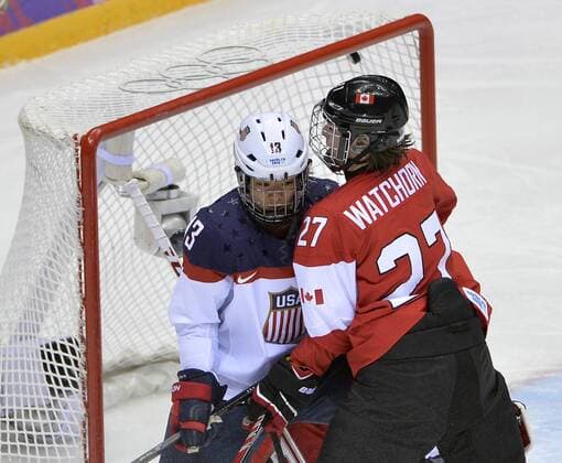 United States Julie Chu screens the goaltender as Canada s Tara Watchhorn defends and United States Meghan Duggan s shot goes in the back of the net for a goal during the second period of the women s gold medal ice hockey game at the Sochi 2014 Winter Olympics on February 20, 2014 in Sochi, Russia.  OLY20140220131