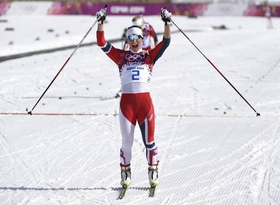 Norway s Marit Bjoergen celebrates after finishing second in the ladies 30 km mass start free cross-country race at the Sochi 2014 Winter Olympics on February 22, 2014 in Krasnaya Polyana, Russia. Norway swept the medals with Bjoergen taking gold, Therese Johaug taking silver and Kristin Stoermer Steira winning bronze.  OLY20140222323