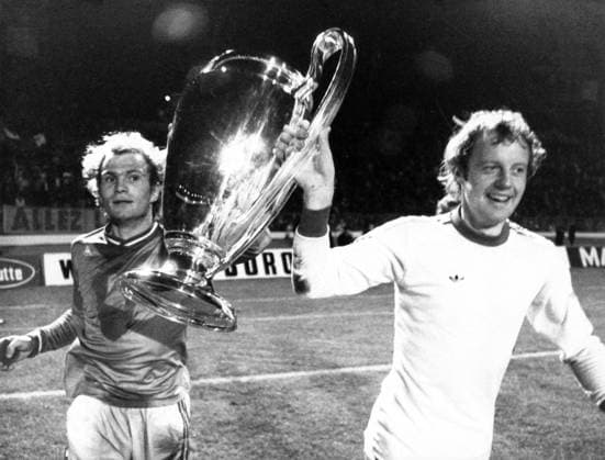 Uli Hoeneß (li.) und Johnny Hansen (beide FC Bayern München) präsentieren die Trophäe nach dem Sieg im Finale um den Europapokal der Landesmeister 1976 in Glasgow