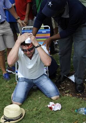 09 March 2014: A fan tries to stop the bleeding from his head after being hit by Tiger Woods tee shot from first tee box during the final round of the World Golf Championships-Cadillac Championship on the Blue Monster course at the Trump National Doral in Doral, FL. GOLF: MAR 09 PGA Golf Herren - World Golf Championships-Cadillac Championship - Final Round Icon20180944 EDITORIAL USE ONLY