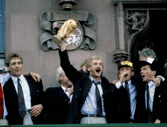 1990 - Weltmeister Deutschland feiert: Rudi Völler mit dem Fussball Weltpokal, daneben Torwart Bodo Illgner (li.), Andreas Brehme (2.v.re.) und Lothar Matthäus beim Empfang in Frankfurt HM