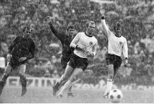 EM76 Viertelfinale Rückspiel vom 22.5.1976: Deutschland - Spanien: Spieler stehen im Regen, v.li.: Juan Manuel Asensi, Jose Antonio Camacho, Uli Hoeneß und Rainer Bonhof HM