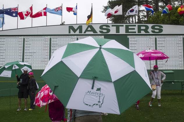 Golf patrons exit the grounds as heavy rain falls during a rain delay during a practice round prior to the Masters golf tournament at Augusta National Golf Club in Augusta, George, April 7, 2014.  AUG20140407306