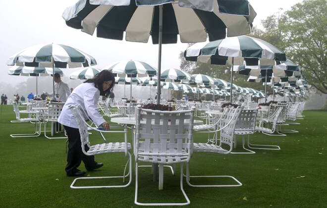Busser Katherine Fauerby cleans tables as she helps set up during a practice round prior to the Masters golf tournament at Augusta National Golf Club in Augusta, George, April 7, 2014.  AUG20140407312