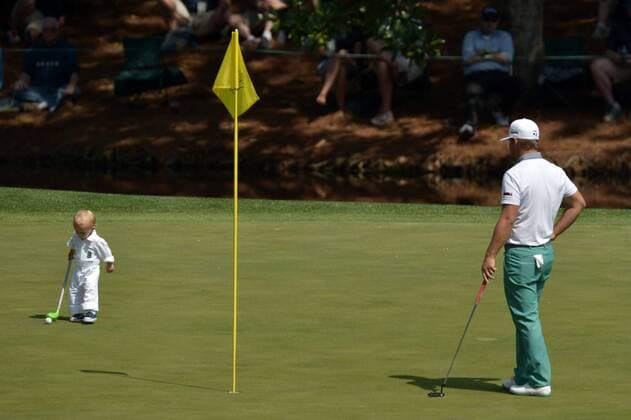 Kevin Streelman watches his son Tucker putt on the eighth green during the Par 3 Contest during the Masters Tournament at Augusta National Golf Club in Augusta, Georgia, April 8, 2014.  AUG20140409348